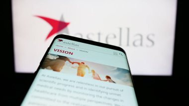 Stuttgart, Almanya - 04-01-2023: Eczacılık şirketi Astellas Pharma Inc. 'in web sitesi olan akıllı telefon, iş logosu önünde ekranda. Telefon ekranının sol üst kısmına odaklan.