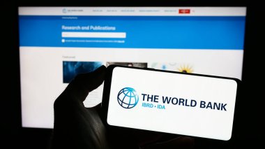 Stuttgart, Almanya - 04-02-2023: Finans kurumu logosu olan cep telefonu sahibi kişi The World Bank iş dünyasının web sayfası önünde ekranda. Telefon ekranına odaklan.
