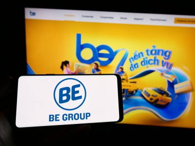 Stuttgart, Almanya - 04-02-2023: Vietnamlı teknoloji şirketi Be Group JSC 'nin logosuyla cep telefonu sahibi kişi iş sayfasının önünde ekranda. Telefon ekranına odaklan.