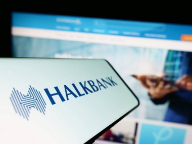 Stuttgart, Almanya - 04-02-2023: Türkiye Halk Bankası (Halkbank) logosu olan akıllı telefon iş dünyasının web sitesi önünde ekranda. Telefon ekranının soluna odaklan.