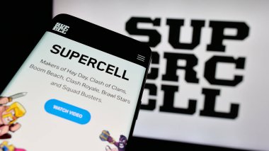 Stuttgart, Germany - 01-15-2025: Smartphone with website of Finnish video games company Supercell Oy on screen in front of business logo. Focus on top-left of phone display. clipart