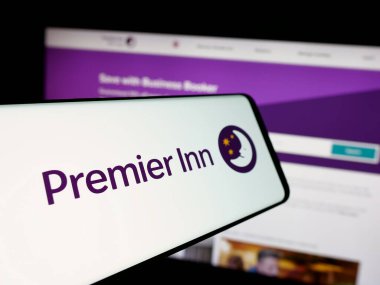 Stuttgart, Almanya - 01-15-2025: İngiliz otel zincir şirketi Premier Inn Limited 'in logosuna sahip akıllı telefon web sitesinin önünde ekranda. Telefon ekranının merkez soluna odaklan.