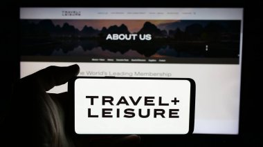 Stuttgart, Almanya - 01-15-2025: ABD 'li devre mülk şirketi Travel Leisure Co' nun logosuyla cep telefonu sahibi kişi iş sayfasının önünde ekranda. Telefon ekranına odaklan.