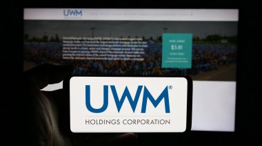 Stuttgart, Almanya - 01-15-2025: ABD 'li mortgage şirketi UWM Holding Corporation' ın logosuyla cep telefonu sahibi kişi iş sayfasının önünde ekranda. Telefon ekranına odaklan.