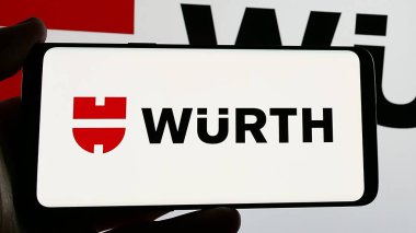 Stuttgart, Germany - 01-15-2025: Smartphone with logo of German tools company Adolf Wuerth GmbH Co. KG on screen. Focus on phone display. clipart