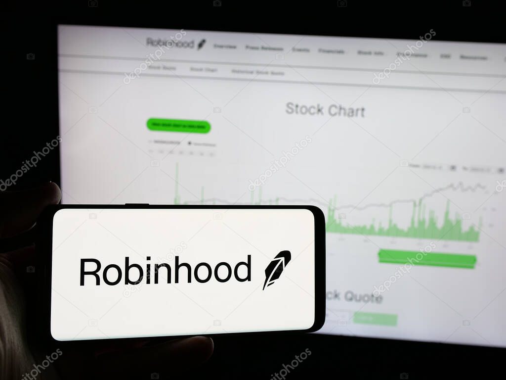 Stuttgart, Germany - 01-15-2025: Person holding smartphone with logo of US financial company Robinhood Markets Inc. on screen in front of website. Focus on phone display.