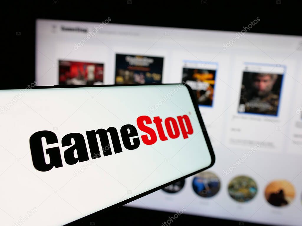 Stuttgart, Germany - 01-15-2025: Mobile phone with logo of American video game retail company GameStop Corp. on screen in front of website. Focus on center-left of phone display.