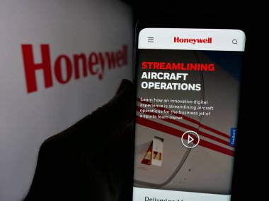 Stuttgart, Almanya - 01-16-2025: ABD 'li şirket Honeywell International Inc.' in web sayfası ile akıllı telefon sahibi kişi logonun önünde ekranda. Telefon ekranının merkezine odaklan.