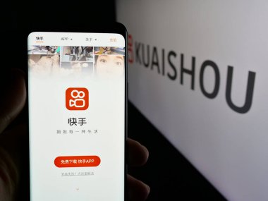 Stuttgart, Almanya - 01-16-2025: Çin video paylaşım uygulaması şirketi Kuaishou 'nun web sayfası ile cep telefonu tutan kişi logonun önünde ekranda. Telefon ekranının merkezine odaklan.