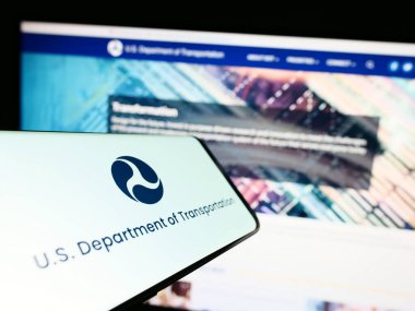 Stuttgart, Almanya - 03-22-2023: ABD Ulaştırma Bakanlığı (USDOT) logosuna sahip cep telefonu web sitesi ile ekranda. Telefon ekranının merkez sağına odaklan.