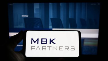 Stuttgart, Almanya - 03-22-2023: Koreli yatırım şirketi MBK Partners Ltd. 'nin logosuna sahip kişi web sitesinin önünde ekranda. Telefon ekranına odaklan.
