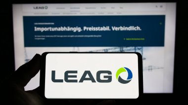 Stuttgart, Almanya - 03-23-2023: Alman enerji şirketi LEAG 'nin logosunun bulunduğu akıllı telefonu web sitesinin önünde tutan kişi. Telefon ekranına odaklan.