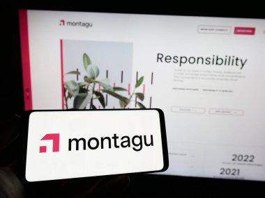 Stuttgart, Germany - 03-23-2023: Person holding mobile phone with logo of investment company Montagu Private Equity LLP on screen in front of web page. Focus on phone display. clipart