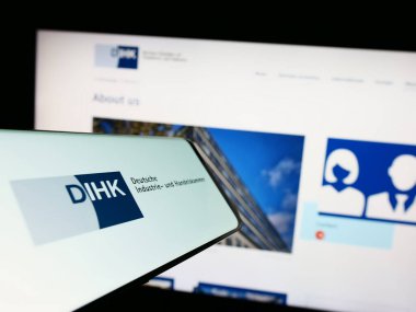 Stuttgart, Almanya - 03-24-2023: Web sitesinin önünde ekranda Deutsche Industri- und Handelskammer (DIHK) logosu olan akıllı telefon. Telefon ekranının merkez sağına odaklan.