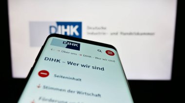 Stuttgart, Almanya - 03-24-2023: Logonun önünde Deutsche Industri- und Handelskammer (DIHK) web sayfası bulunan cep telefonu. Telefon ekranının sol üst kısmına odaklan.