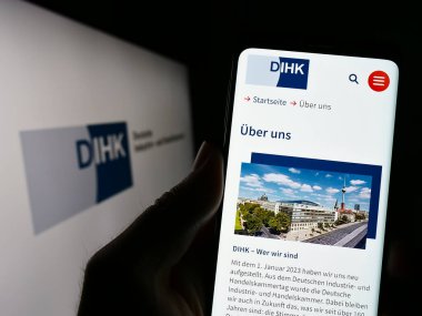 Stuttgart, Almanya - 03-24-2023: Deutsche Industrie- und Handelskammer 'in (DIHK) internet sitesi olan cep telefonu ekranda. Telefon ekranının merkezine odaklan.