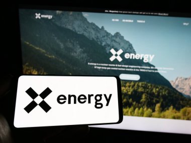 Stuttgart, Almanya - 03-25-2023: ABD 'li nükleer enerji şirketi X Energy LLC' nin logosuna sahip akıllı telefonu web sitesinin önünde ekranda tutan kişi. Telefon ekranına odaklan.