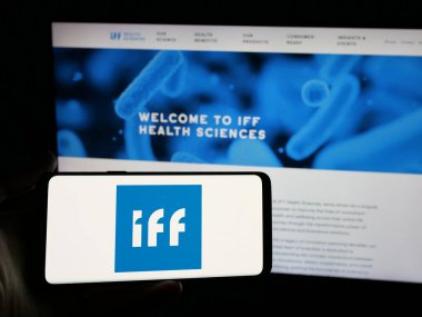 Stuttgart, Almanya - 01-17-2025: İnternet sitesi önünde üzerinde International Flavors Fragrances Inc. (IFF) logosu bulunan kişi. Telefon ekranına odaklan.
