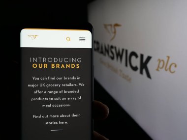 Stuttgart, Almanya - 01-17-2025: İngiliz gıda şirketi Cranswick plc 'in web sayfası olan akıllı telefon sahibi kişi logonun önünde ekranda. Telefon ekranının merkezine odaklan.