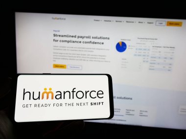 Stuttgart, Almanya - 03-25-2023: Avustralyalı yazılım şirketi Humanforce 'un logosuyla cep telefonu sahibi kişi iş sayfasının önünde ekranda. Telefon ekranına odaklan.