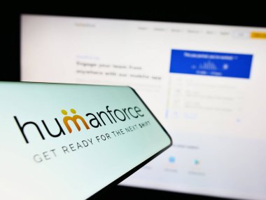 Stuttgart, Germany - 03-25-2023: Mobile phone with logo of Australian software company Humanforce on screen in front of business website. Focus on center of phone display. clipart