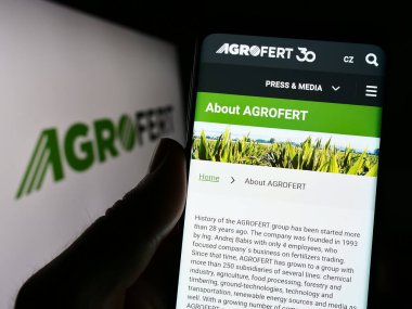 Stuttgart, Almanya - 03-25-2023: Çek Agrofert A.s. şirketinin web sitesi ile akıllı telefonu olan kişi iş logosu önünde ekranda. Telefon ekranının merkezine odaklan.