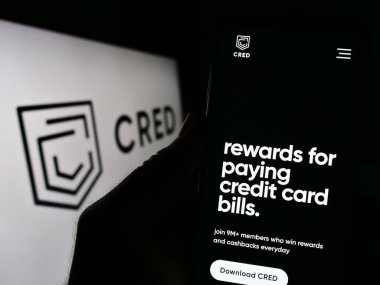 Stuttgart, Almanya - 03-25-2023: Dreamplug Technologies Pvt Ltd. (CRED) adlı şirketin internet sitesi olan kişi ekranda logolu. Telefon ekranının merkezine odaklan.