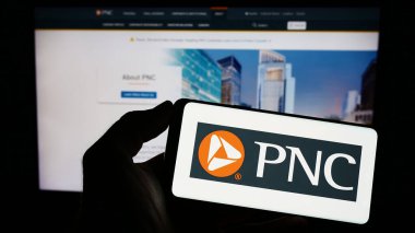 Stuttgart, Almanya - 03-25-2023: Amerikan PNC Finansal Hizmet Grubu 'nun logosunun bulunduğu cep telefonu web sayfası önünde ekranda. Telefon ekranına odaklan.