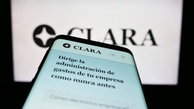 Stuttgart, Almanya - 03-25-2023: Meksikalı fintech şirketi Clara 'nın web sayfası ile cep telefonu iş logosu önünde ekranda. Telefon ekranının sol üst kısmına odaklan.