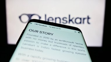 Stuttgart, Almanya - 03-26-2023: Hintli gözlük şirketi Lenskart 'ın web sayfalı akıllı telefon iş logosu önünde ekranda. Telefon ekranının sol üst kısmına odaklan.