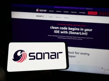 Stuttgart, Almanya - 03-26-2023: İsviçreli yazılım şirketi SonarSource S.A. 'nın logosuyla cep telefonu sahibi kişi iş sayfasının önünde ekranda. Telefon ekranına odaklan.