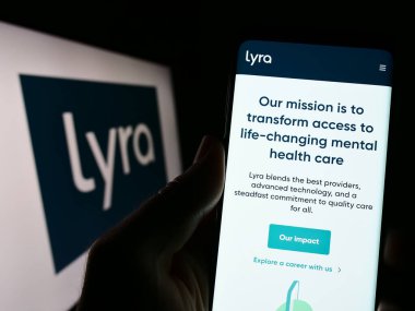 Stuttgart, Almanya - 03-26-2023: ABD 'li akıl sağlığı şirketi Lyra Health Inc.' in web sayfası ile akıllı telefon sahibi kişi logonun önünde ekranda. Telefon ekranının merkezine odaklan.