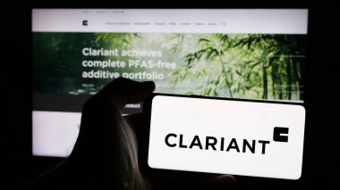 Stuttgart, Almanya - 01-20-2025: Üzerinde İsviçreli özel kimya şirketi Clariant AG 'nin logosu olan cep telefonu sahibi kişi web sayfasının önünde ekranda. Telefon ekranına odaklan.
