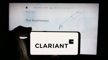 Stuttgart, Almanya - 01-20-2025: Üzerinde İsviçreli özel kimya şirketi Clariant AG 'nin logosu olan cep telefonu sahibi kişi iş sayfasının önünde ekranda. Telefon ekranına odaklan.