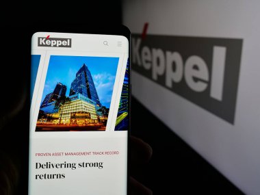 Stuttgart, Almanya - 01-22-2025: Singapur şirketi Keppel Ltd. 'nin web sayfası ile akıllı telefonu olan kişi iş logosu önünde ekranda. Telefon ekranının merkezine odaklan.