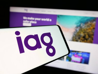 Stuttgart, Almanya - 01-22-2025: Şirket logosu olan cep telefonu şirketi Insurance Australia Group Limited (IAG) iş sitesinin önünde ekranda. Telefon ekranının merkezine odaklan.