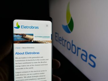 Stuttgart, Almanya - 01-23-2025: Centrais Eletricas Brasileiras S.A. (Elektrobras) sitesinin web sayfası logolu cep telefonu tutan kişi. Telefon ekranının merkezine odaklan.