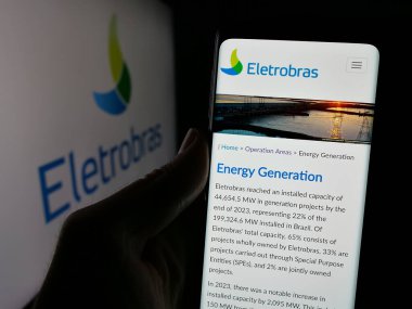 Stuttgart, Almanya - 01-23-2025: Centrais Eletricas Brasileiras S.A. 'nın (Elektrobras) web sayfası logolu akıllı telefon sahibi kişi. Telefon ekranının merkezine odaklan.