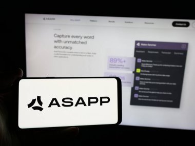 Stuttgart, Almanya - 01-23-2025: Web sitesi önünde ekranda ABD 'li yapay zeka şirketinin logosuna sahip akıllı telefonu tutan kişi. Telefon ekranına odaklan.