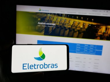 Stuttgart, Almanya - 01-23-2025: İnternet sitesinin önünde Centrais Eletricas Brasileiras S.A. (Electrobras) logosu olan akıllı telefon sahibi kişi. Telefon ekranına odaklan.