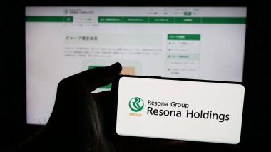 Stuttgart, Almanya - 01-23-2025: Japon bankacılık şirketi Resona Holding Inc. 'nin logosunun bulunduğu cep telefonu web sayfası önünde ekranda. Telefon ekranına odaklan.