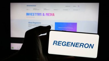 Stuttgart, Almanya - 01-23-2025: ABD 'li biyoteknoloji şirketi Regeneron Pharmaceuticals Inc.' in logosunun bulunduğu cep telefonu web sayfasının önünde. Telefon ekranına odaklan.