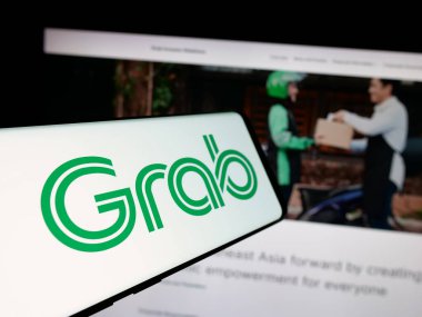 Stuttgart, Almanya - 01-23-2025: Singapur teknoloji şirketi Grab Holding Inc. 'nin logosunu içeren cep telefonu web sitesinin önünde ekranda. Telefon ekranının merkez soluna odaklan.