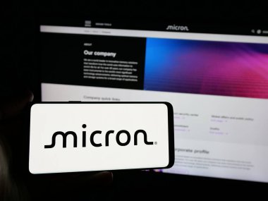 Stuttgart, Almanya - 01-23-2025: İnternet sitesi önünde ekranda üzerinde ABD 'li yarı iletken şirket Micron Technology Inc.' in logosu bulunan akıllı telefon sahibi kişi. Telefon ekranına odaklan.