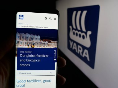 Stuttgart, Almanya - 01-23-2025: Norveçli kimya şirketi Yara International ASA 'nın internet sayfası ile akıllı telefonu elinde tutan kişi logolu ekranda. Telefon ekranının merkezine odaklan.