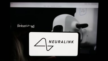 Stuttgart, Almanya - 01-23-2025: ABD 'li nöroteknoloji şirketi Neuralink Corp' un logosunun bulunduğu cep telefonu sahibi kişi iş sayfasının önünde ekranda. Telefon ekranına odaklan.