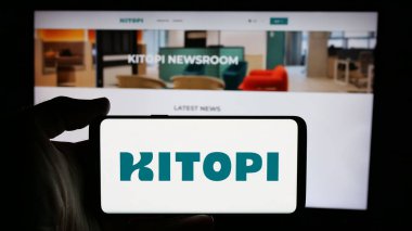 Stuttgart, Almanya - 01-23-2025: Arap gastronomi şirketi Kitopi 'nin logosunun bulunduğu cep telefonu sahibi kişi iş sayfasının önünde ekranda. Telefon ekranına odaklan.