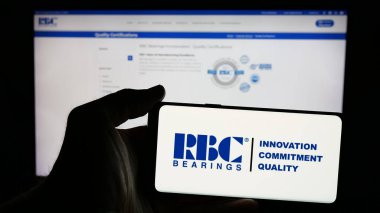 Stuttgart, Almanya - 01-24-2025: Amerikan şirketi RBC Bearings Inc. 'in logosunun bulunduğu cep telefonu sahibi kişi iş sayfasının önünde ekranda. Telefon ekranına odaklan.