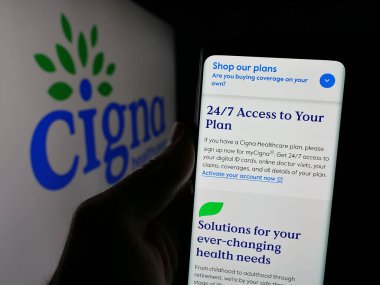 Stuttgart, Almanya - 01-24-2025: ABD 'li sağlık şirketi Cigna Healthcare' in web sayfası ile logo önünde cep telefonu tutan kişi. Telefon ekranının merkezine odaklan.