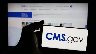 Stuttgart, Almanya - 01-28-2025: İnternet sayfası önünde üzerinde Medicare Medicaid Services (CMS) logosu bulunan cep telefonu sahibi kişi. Telefon ekranına odaklan.